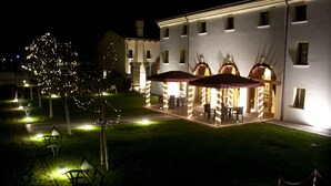 Zona exterior bien iluminada con un conjunto de asientos y la entrada a un edificio.