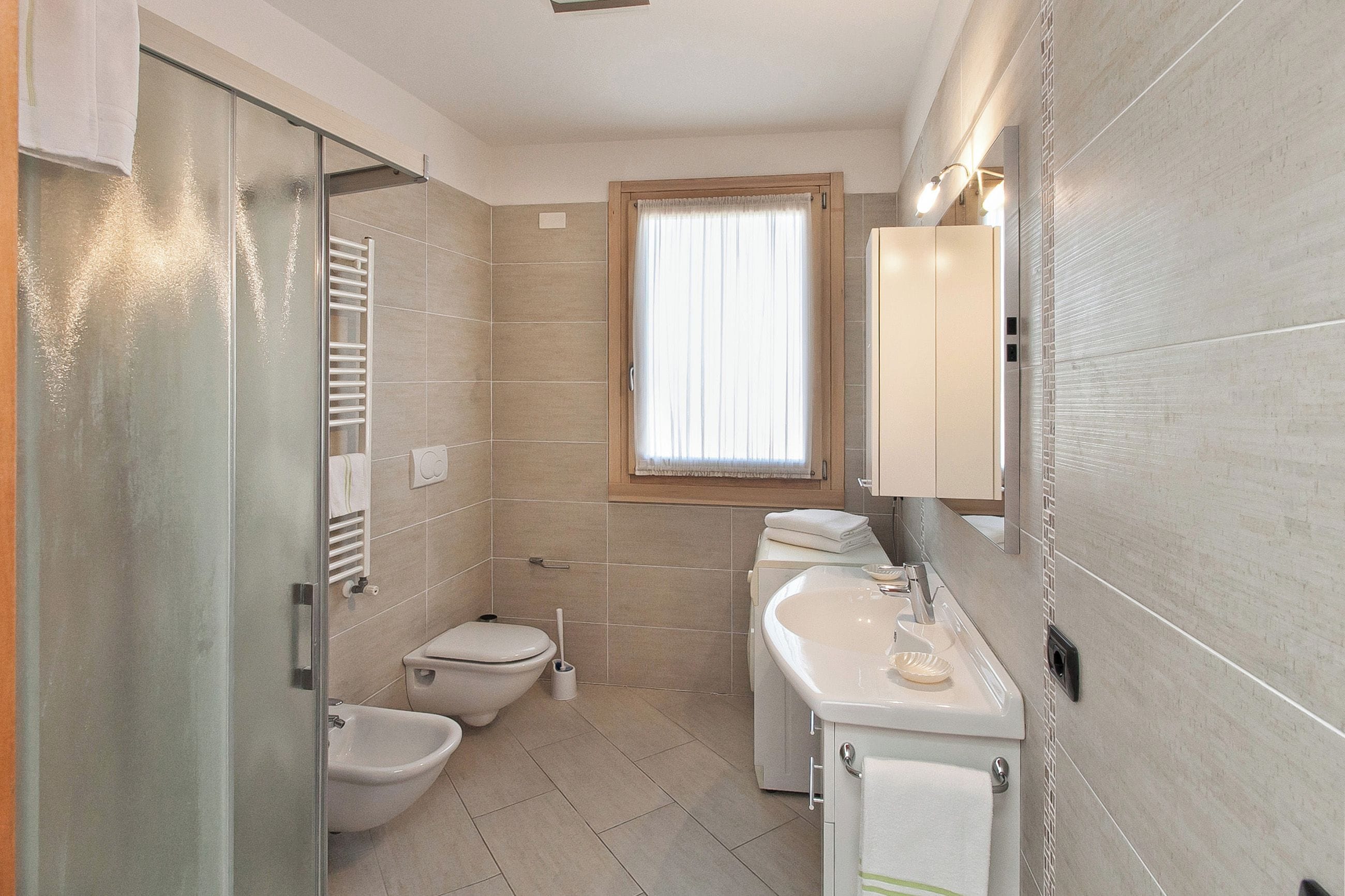 A compact bathroom with a toilet, bidet, and sink.