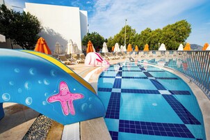 Una piscina al aire libre de temporada, sombrillas, tumbonas