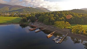 An aerial view of a lakeside village with a dock, boats, and a church. - Embleton Spa Hotel (Cockermouth)