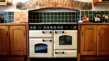 A kitchen with a double oven, wooden cabinets, and a tiled backsplash.