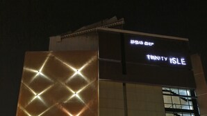 A building with a large illuminated sign reading "TRINITY ISLE" and a modern architectural design. - Hotel Trinity Isle (Bengaluru)