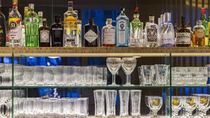 Un bar con numerosas estanterías llenas de botellas de licor y vasos.