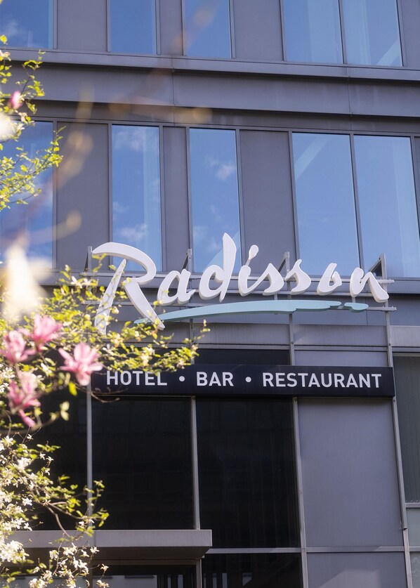 A building with a sign that reads 'Radissen' and a lower sign indicating 'HOTEL • BAR • RESTAURANT'. - Radisson Hotel Brussels Centre Midi (Brussels)