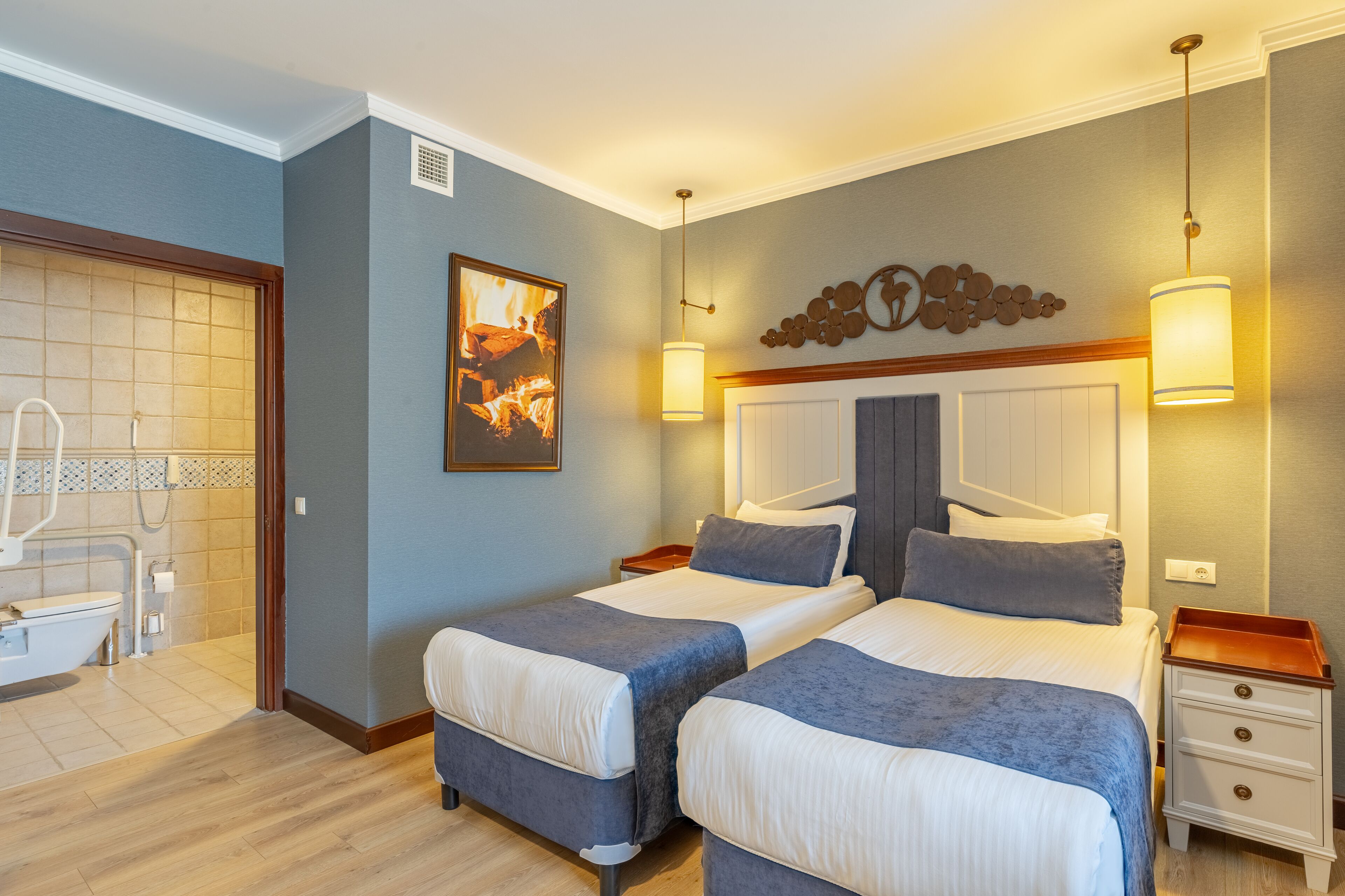 A hotel room with two beds, a bathroom with a bathtub, and a decorative wall piece.
