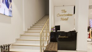 Zona de recepción de un hotel con una escalera que conduce a los pisos superiores.