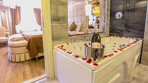 Un baño lujoso con una bañera grande, una botella de champán y copas.