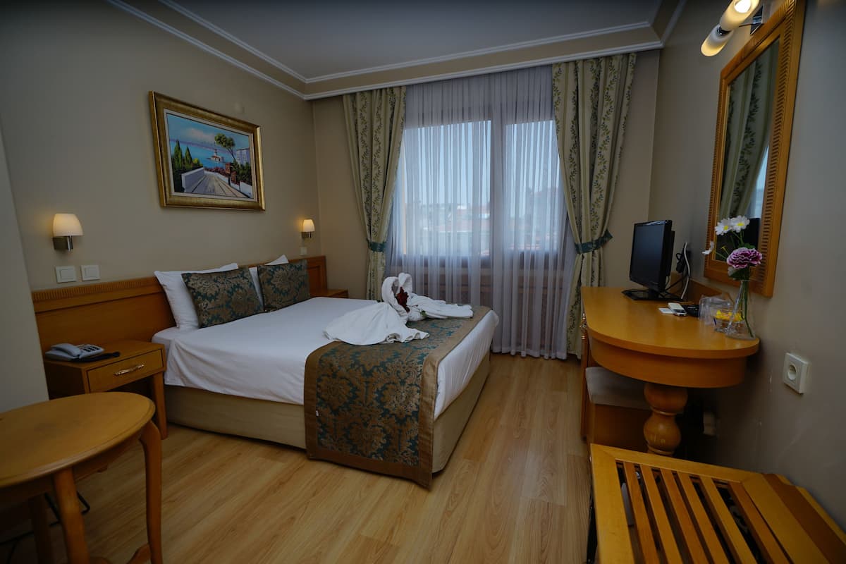 Standaard eenpersoonskamer | Luxe beddengoed, een minibar, een kluis op de kamer, een bureau