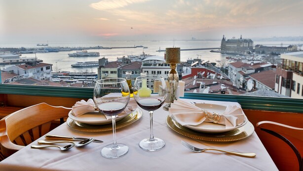 Ein Tisch für zwei mit Blick auf einen Hafen und ein historisches Gebäude gegenüber.