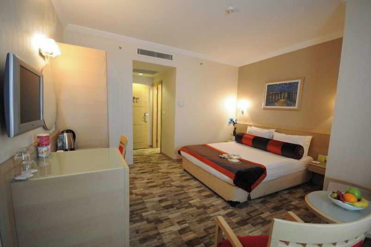 Ein Hotelzimmer mit Bett, Nachttisch und einem kleinen Tisch mit Obst.