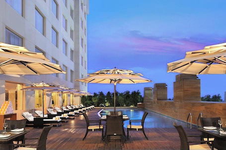 Outdoor pool, pool umbrellas. Four Points by Sheraton Hotel & Serviced Apartments, Pune
