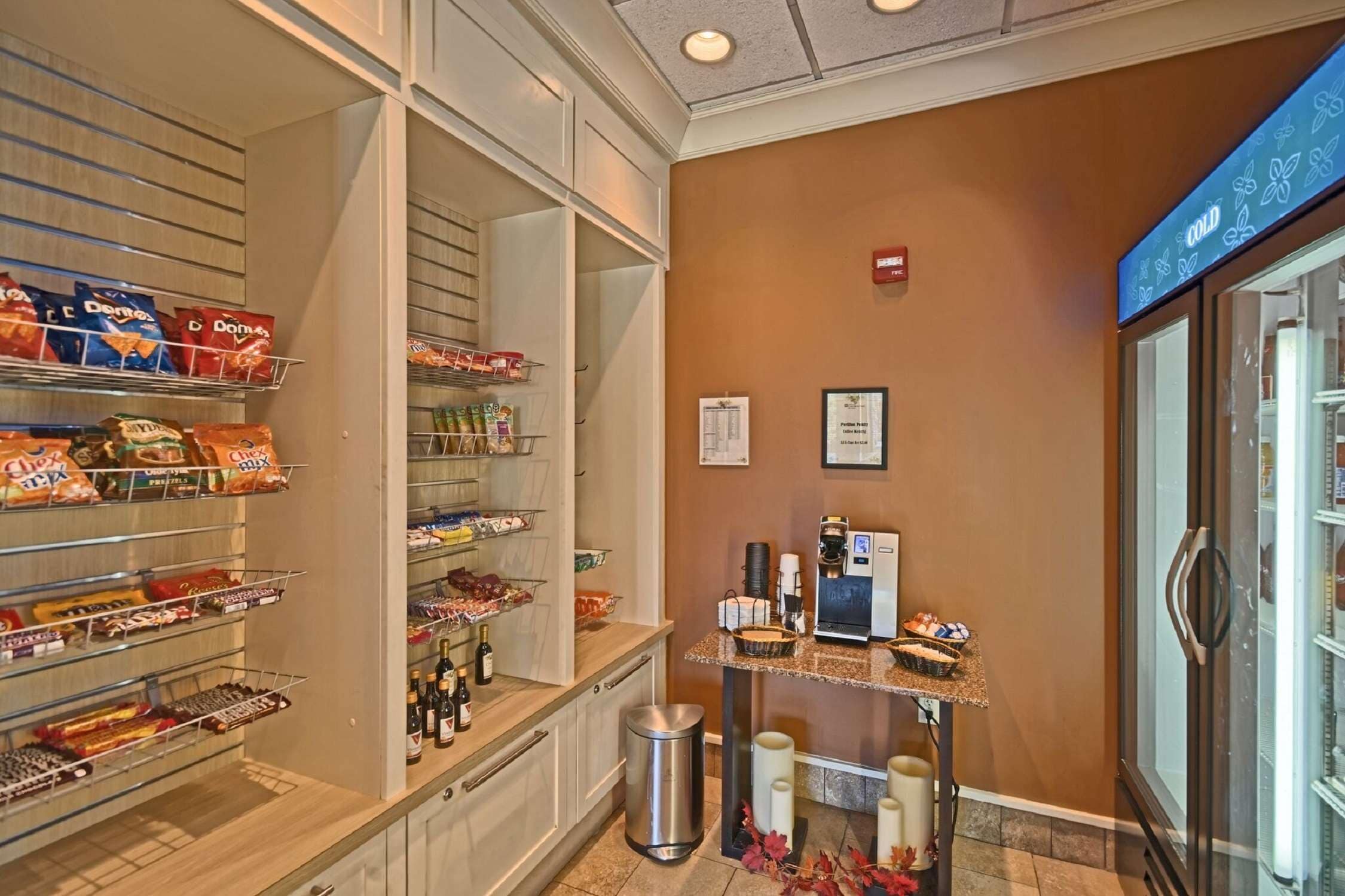 A hotel pantry with snacks, beverages, and a coffee machine.