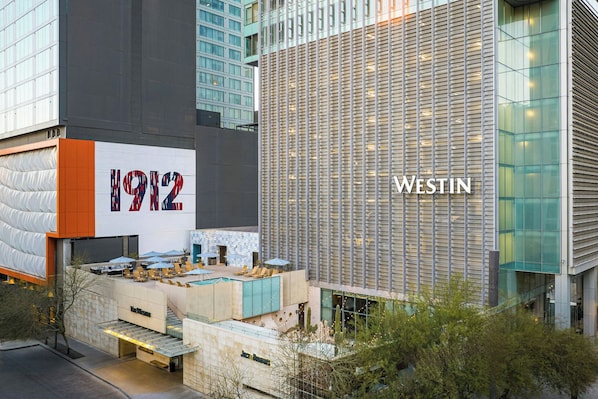 A modern hotel with a prominent '1912' sign, outdoor seating area, and a pool. - The Westin Phoenix Downtown (Phoenix)