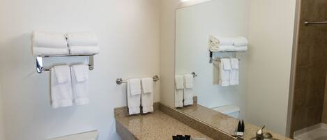 Une salle de bain moderne avec des toilettes, un lavabo et un grand miroir.