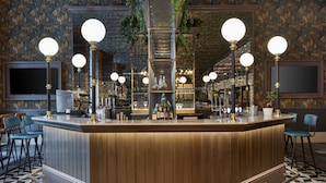 A bar area with a central counter, multiple bar stools, and a patterned floor.