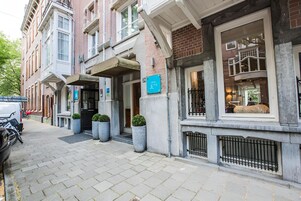 Un bâtiment doté d’une façade en pierre, de grandes fenêtres et d’une enseigne indiquant qu’il s’agit d’un restaurant.