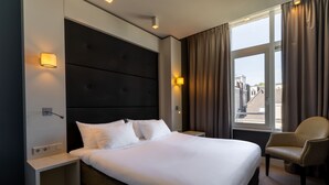 A modern hotel room with a large bed, two bedside tables, a chair, and a window with curtains. - Hotel JL No76 (Amsterdam)