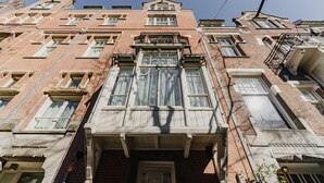 A multi-story brick building with large windows and a central entrance. - Hotel JL No76 (Amsterdam)