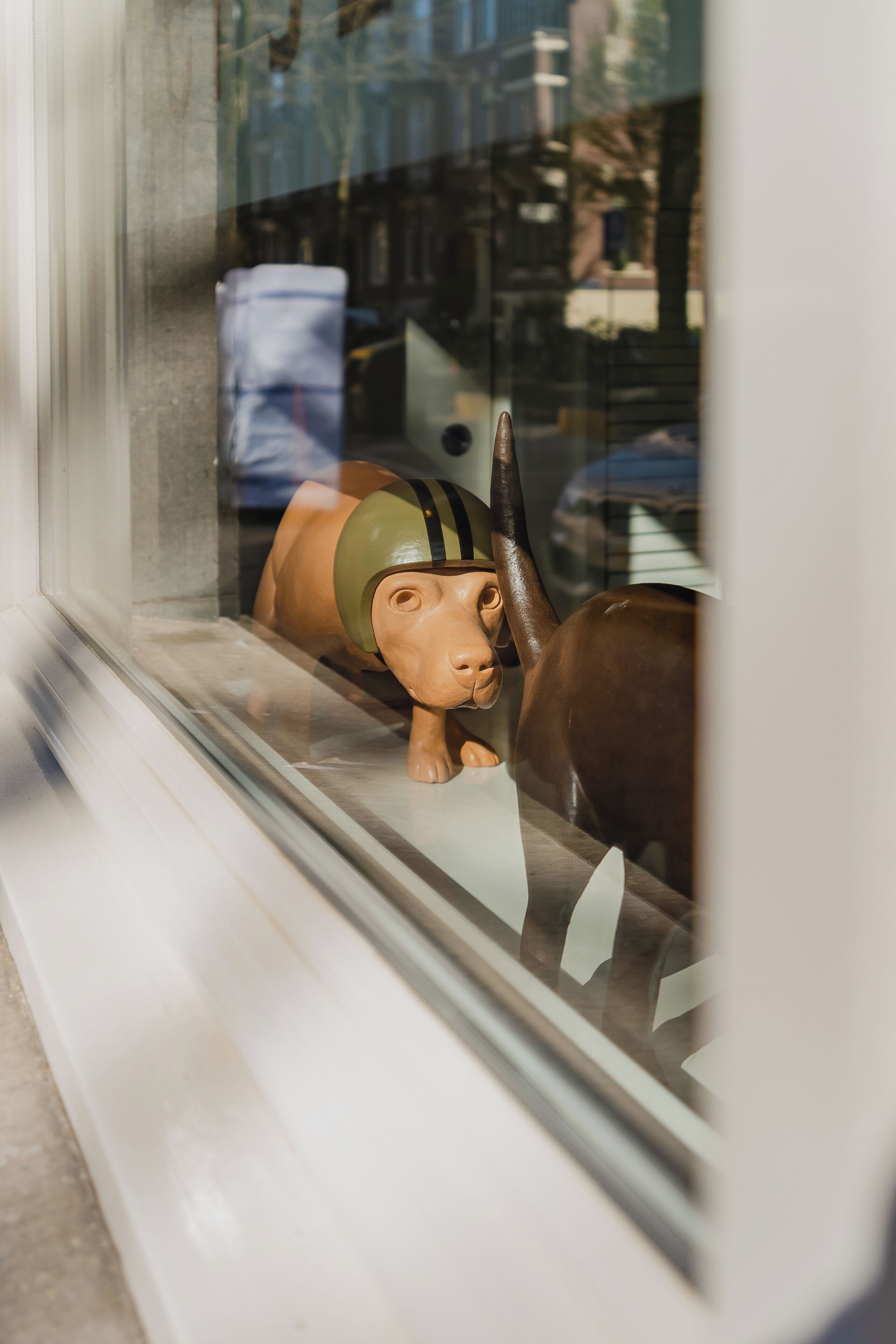 A window display with a toy horse and a toy cow.
