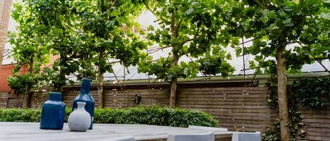 A table set outdoors with vases and a wooden fence in the background.
