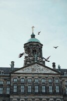 A historic building with a prominent dome and statues.