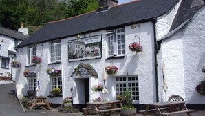 A white building with a sign reading "The Century Free House" and a pub sign. There are outdoor seating areas with benches and tables. - The Who'd Have Thought It Inn (Yelverton)