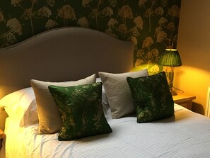 A neatly made bed with white bedding and two green patterned pillows. - The Who'd Have Thought It Inn (Yelverton)