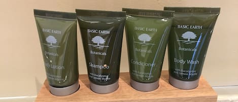Four Basic Earth Botanicals products on a wooden shelf.