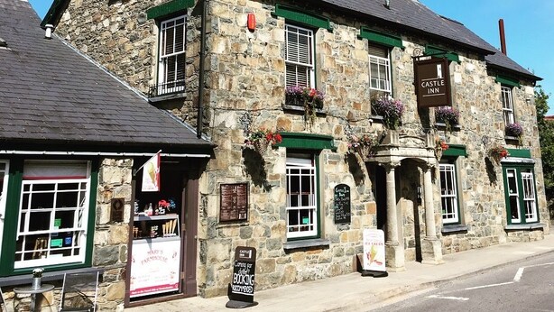 Un edificio de piedra con un letrero que dice 'Castle Inn'.
