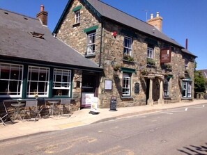 A stone building with a sign reading "CASTLE INN".