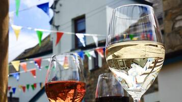 Two wine glasses on a table, one with red wine and one with white wine, under colorful triangular flags.