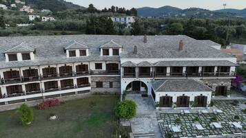 Un edificio tradicional con varios balcones, un patio con asientos y vistas del paisaje circundante.
