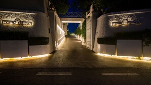 A well-lit pathway leading to a hotel entrance with illuminated signage reading "HOTEL VILLA IREOS." - Hotel Villa Ireos (Ischia)