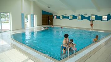 Swim laps in the spacious pool surrounded by walls with windows.