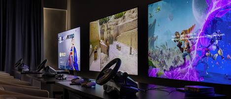 A gaming setup with multiple monitors, a steering wheel, and a VR headset.