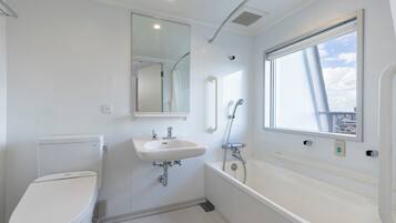 A modern bathroom with a toilet, sink, and bathtub.