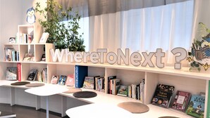 A modern library with bookshelves, seating areas, and a large 'WhereToNext?' sign. - Tokyu Stay Ikebukuro (Tokyo)