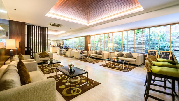 A spacious lobby with multiple seating areas, large windows with blinds, and a modern ceiling design. - Lohas Residences Sukhumvit (Bangkok)