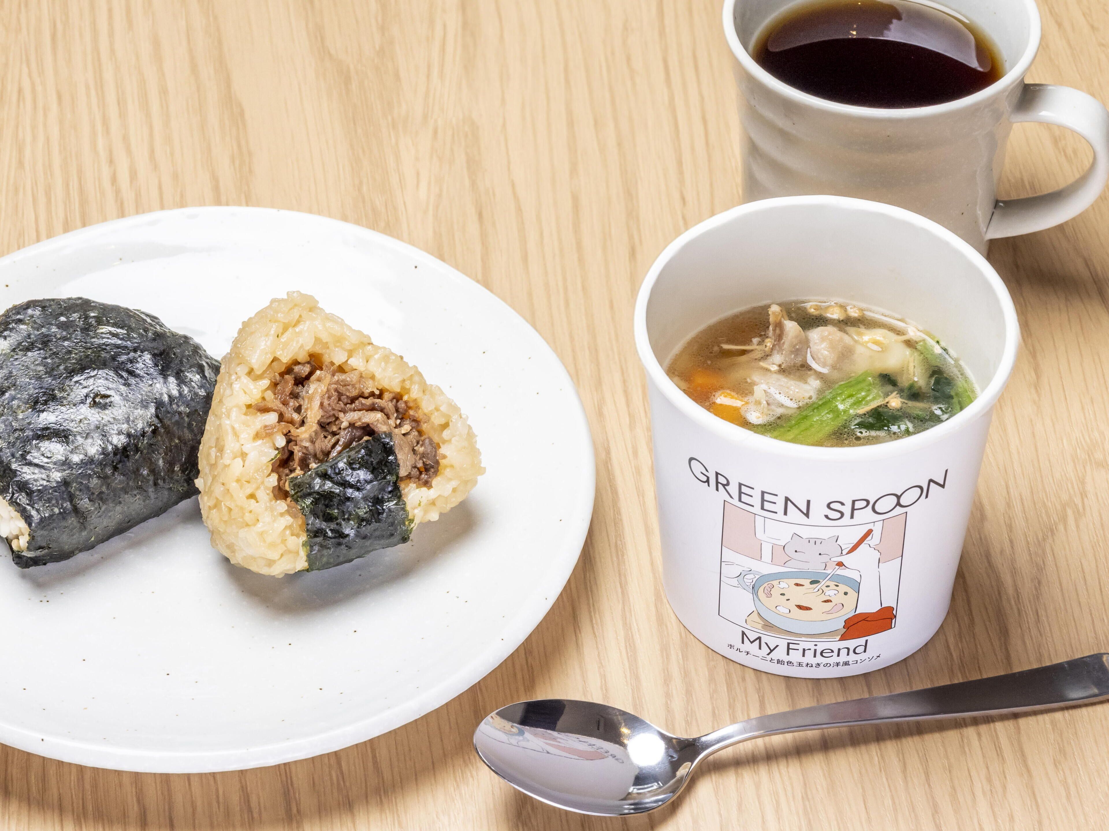 Een bord met twee sushirollen en een kom soep met een lepel.