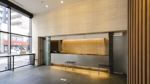 A modern reception area with a large window, a reception desk, and a counter. - Tokyu Stay Kamata - Tokyo Haneda (Tokyo)