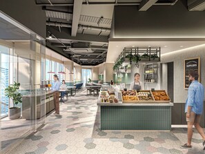 A modern cafe interior with a central counter displaying pastries, a seating area with tables and chairs, and a view of the city through large windows. - Tokyu Stay Gotanda (Tokyo)