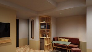 A modern living room with a flat-screen TV, a wooden bookshelf, a red sofa, a small table, and a round rug. - Tokyu Stay Gotanda (Tokyo)