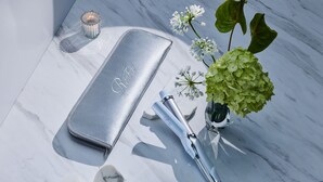 A marble surface with a silver case, a hairbrush, a vase with flowers, and a candle. - Tokyu Stay Gotanda (Tokyo)