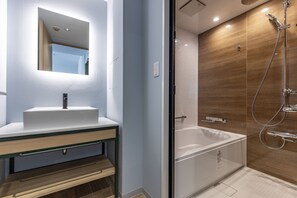 Een aparte badkuip en douche, een regendouche, gratis toiletartikelen