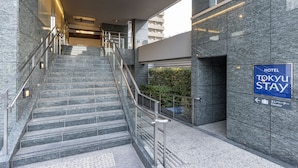 A modern hotel entrance with a marble staircase, a sign for the Tokyo Stay Hotel, and an elevator sign. - Tokyu Stay Shibuya Shin-minamiguchi (Tokyo)