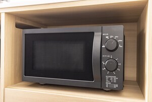 A microwave in a wooden cabinet.