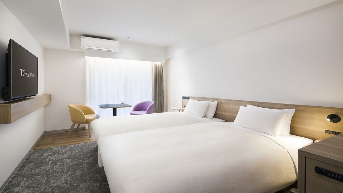 Une chambre d’hôtel avec un grand lit, une télévision, un bureau et une chaise.