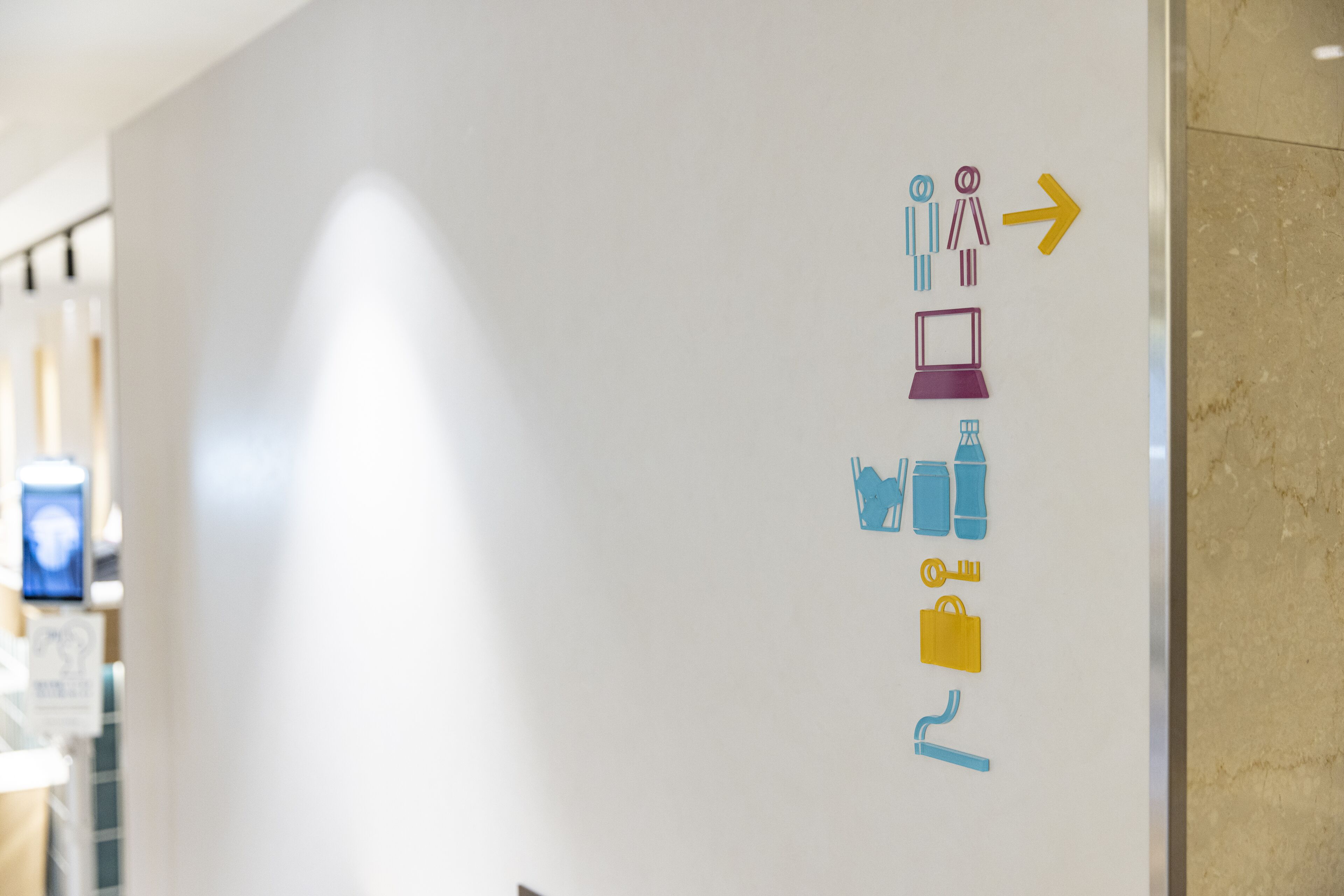 A whiteboard with directional arrows and icons indicating amenities such as restrooms, a computer, water, a safe, and a smoking area.