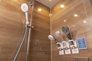 A modern shower area with multiple shower heads and a wooden wall.