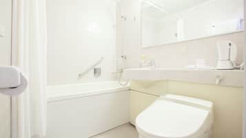 A modern bathroom with a bathtub, toilet, and a sink with a mirror above.